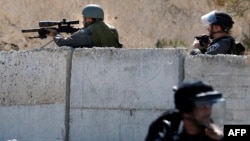 An Israeli security forces sniper aims his weapon toward Palestinian protesters during clashes in the east Jerusalem Arab neighborhood of Issawiya, Oct. 4, 2015. 