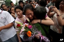 FILE - A Chinese student is greeted by a relative after taking the annual college entrance examinations in Beijing, June 8, 2010.
