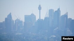 A ferry passes in front of the Central Business District as smoke from bushfires shroud Sydney, Australia, Nov. 11, 2019. 