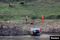 FILE - A Chinese team of geologists surveys the Mekong River banks, at the Laos side, at the border between Laos and Thailand, April 23, 2017.