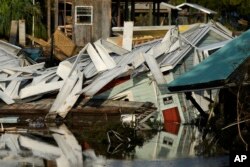 FILE - A home sits partially submerged in a canal in Horseshoe Beach, Florida, on Sept. 1, 2023, two days after the passage of Hurricane Idalia. Last year had 20 named storms, the fourth-highest year since 1950.