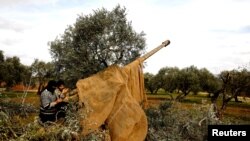 Syrian fighters set a target to an artillery near Idlib, Syria, Feb. 27, 2020.