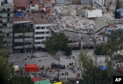 Rescue workers search for people trapped inside a collapsed building in the Roma Norte neighborhood of Mexico City, Sept. 20, 2017.