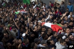 Palestinians carry the bodies of Ahmed Abu al-Aish, 28, and Laith Manasrah, 21, during their funeral in the Qalandia refugee camp on the outskirts of the West Bank city of Ramallah, Nov. 16, 2015.