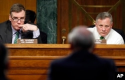 Senate Intelligence Committee Chairman Richard Burr, R-N.C., right, and Committee Vice chairman Mark Warner, D-Va., left, listen on Capitol Hill in Washington, Feb. 28, 2017, as Director of National Intelligence-designate Dan Coats testifies at his confirmation hearing.