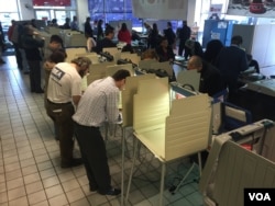 People vote at a polling location in Chicago's Precinct 6 Ward 45, inside a Nissan dealership on Irving Park Road in Illinois, March 15, 2016. (K. Farabaugh/VOA)