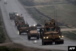FILE - A convoy of US military vehicles is seen in Syria's northern city of Manbij, Dec. 30, 2018.
