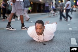 A man lays on the ground after yelling "Don't shoot me" at police during a rally in Dallas, Texas, on Thursday, July 7, 2016 to protest the deaths of Alton Sterling and Philando Castile.