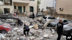 People search through the rubble of a destroyed building at the site of an Israeli airstrike in central Beirut's Ras el-Nabaa neighborhood, Lebanon, Nov. 17, 2024.