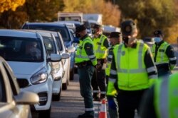 FILE - Guardia Civil officers stop vehicles at a checkpoint in Somosierra, Spain, Oct. 30, 2020.