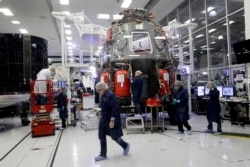 SpaceX employees work on the Crew Dragon spacecraft that will astronauts to and from the International Space Station, from American soil, as part of the agency's commercial crew Program, in Hawthorne, Calif., Thursday, Oct. 10, 2019.