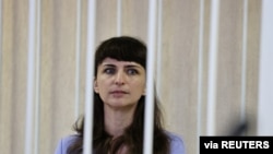 FILE - Journalist Katerina Borisevich sits inside a defendants' cage during a court hearing in Minsk, Belarus, March 2, 2021. (Sergei Sheleg/BelTA/Handout via Reuters)