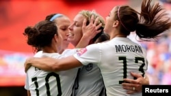United States forward Abby Wambach (20) is congratulated by midfielder Carli Lloyd (10) and forward Alex Morgan (13)\ after scoring against Nigeria during the first half in a Group D soccer match, June 16, 2015.
