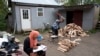 FILE - A girl studies for school while a man chops wood in the Muslim enclave of Islamberg in Tompkins, New York.