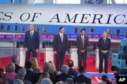 Republican presidential candidates, former New York Gov. George Pataki, left, former Pennsylvania Sen. Rick Santorum, second from left, Louisiana Gov. Bobby Jindal, second from right, and Sen. Lindsey Graham, R-S.C., take the stage in the early CNN Republ