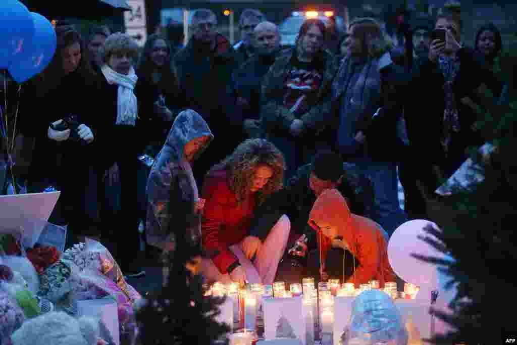 People gather at a memorial for victims near the school on the first Sunday following the mass shooting at Sandy Hook Elementary School on December 16, 2012 in Newtown, Connecticut.