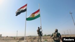 A member of Iraqi security forces takes down the Kurdish flag in Kirkuk, Iraq, Oct. 16, 2017. 