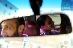 Bahaa Magdy dan istrinya Hebatallah Adel, mengangkut seekor anjing di dalam mobilnya di Kairo, Mesir, 20 Maret 2021. (REUTERS / Hanaa Habib)