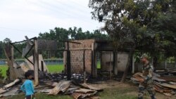 FILE - A paramilitary soldier patrols past a shop that was set on fire in Rowa village, about 220 kilometers from Agartala, in the northeastern Indian state of Tripura, Oct. 27 2021.