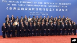 Delegates pose for a group photo at the signing ceremony for the Articles of Agreement of the Asian Infrastructure Investment Bank (AIIB) at the Great Hall of the People in Beijing, June 29, 2015.