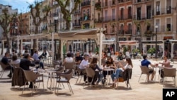 Ljudi sjede u bašti kafića u Taragoni, u Španiji (Foto: AP)