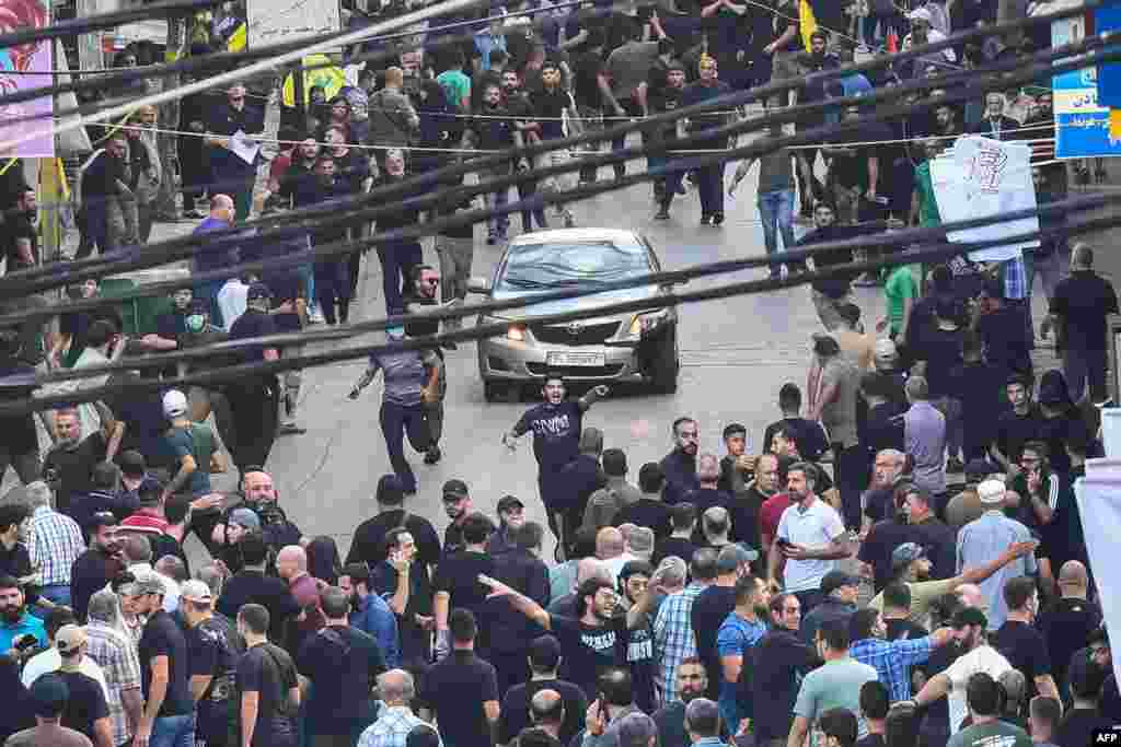 People react around a car after a reported explosion occurred during the funeral of those killed when hundreds of paging devices exploded across Lebanon the previous day, in Beirut's southern suburbs. A second wave of device explosions killed three people in Hezbollah strongholds of Lebanon on September 18.