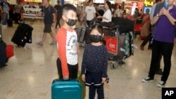 资料照：戴着口罩的儿童从武汉抵达悉尼机场。（2020年1月23日）