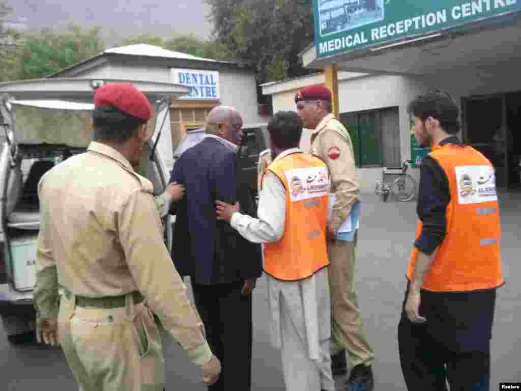 Staff members help a person who was injured during a helicopter crash, at the Combined Military Hospital in Gilgit, Pakistan, May 8, 2015.