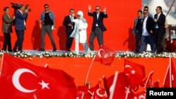 Presiden Turki Recep Tayyip Erdogan dan istrinya Emine Gulbaran dalam sebuah kampanye partai berkuasa AKP di Istanbul (7/8). (Reuters/Osman Orsai)