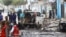 Security officers gather at the scene of a suicide car bombing at a street junction near the president's residence, in Mogadishu, Somalia, Sept. 25, 2021.