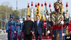 Le dirigeant nord-coréen Kim Jong Un et le président sud-coréen Moon Jae-in marchent ensemble dans le village frontalier de Panmunjom, dans la zone démilitarisée, le 27 avril 2018.