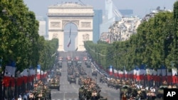 French soldiers stand in an armored vehicle during the Bastille Day parade in Paris, July 14, 2013.