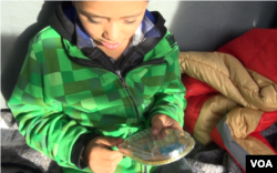 Alex, a migrant child from Honduras, waits with his father at the El Paso del Norte Bridge between Mexico and the U.S. for a chance to request asylum. The eight-year-old said he missed his mother who had to stay behind in his home country. When asked what would he tell his mother if you could talk to her right now, Alex said “that I love her.” (VOA video screengrab)