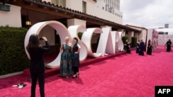 Celebrities and guests walk the red carpet at the Oscars in Los Angeles, California, April 25, 2021.