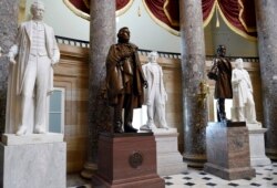 FILE - In this June 24, 2015 file photo, a statue of Jefferson Davis, second from left, president of the Confederate States from 1861 to 1865, is on display in Statuary Hall on Capitol Hill in Washington. (AP Photo/Susan Walsh, File)