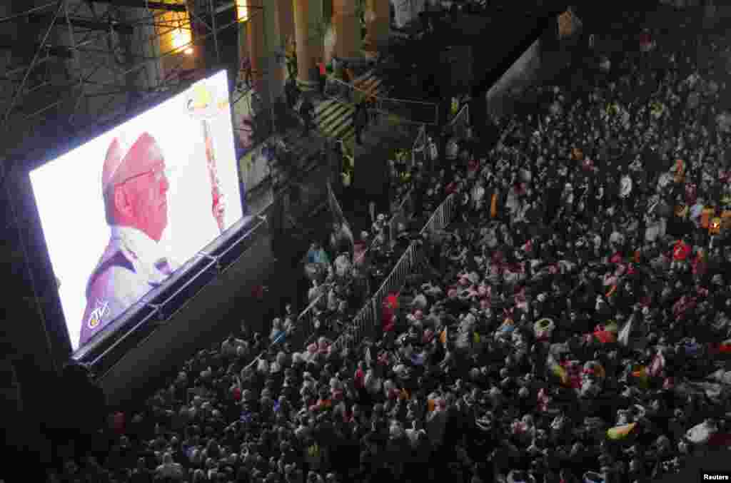 Faithful watch the inaugural mass of Pope Francis on a giant screen next to the Metropolitan Cathedral in Buenos Aires, Argentina, March 19, 2013.