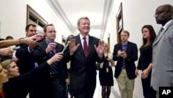 Senate Finance Committee Chairman Sen. Max Baucus, fends off reporters as he arrives to meet in the Capitol Hill office of Sen. John Kerry, and other Supercommittee members in Washington, Nov. 21, 2011