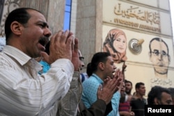 FILE - Journalists and activists protest against the restriction of press freedom and to demand the release of detained journalists, in front of the Press Syndicate in Cairo, April 26, 2016.