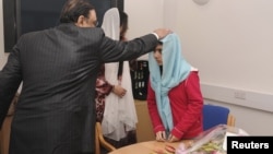Pakistan's President Asif Zardari meets with schoolgirl Malala Yousufzai (R) during his visit to the Queen Elizabeth Hospital in Birmingham, England, December 8, 2012.