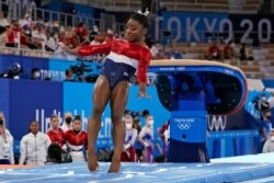 Simone Biles stumbles on the landing after performing on the vault during the artistic gymnastics women's final at the 2020 Summer Olympics, July 27, 2021, in Tokyo.