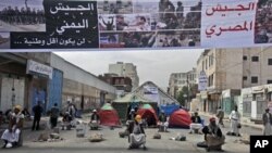 Anti-government protesters guard the site of a demonstration demanding the resignation of Yemeni President Ali Abdullah Saleh, in Sana'a, Yemen, March 17, 2011