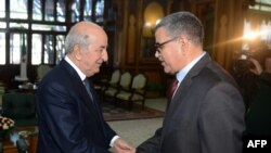 A handout picture released by the official Algeria Press Service (APS) shows Algerian President Abdelaziz Tebboune (L) receiving newly-appointed Prime Minister Abdelaziz Djerad in the capital Algiers, Dec. 28, 2019.