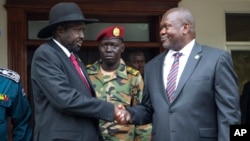 Presiden Sudan Selatan Salva Kiir, kiri, dan Wakil Presiden Pertama Riek Machar, kanan, berjabat tangan setelah pertemuan di Juba, Sudan Selatan, 20 Oktober 2019.