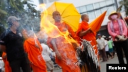 Buddhist monks and other protesters are seen gathered near the Vietnamese embassy during a protest in Phnom Penh, Aug. 13, 2014.