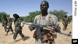 A JEM fighter escorts AU Force Commander General Martin Luther Agwai (third from left) and JEM's Khalil Ibrahim (second from left), in Darfur, October 2007. (AP)