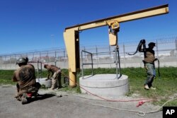 Members of the Border Patrol's Border Tunnel Entry Team work near a tunnel entrance in between two border barriers separating San Diego and Tijuana, Mexico, in San Diego, March 6, 2017.