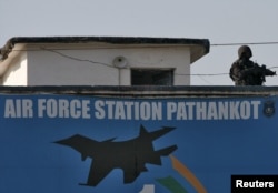 An Indian security personnel stands guard on a building at the Indian Air Force (IAF) base at Pathankot in Punjab, India, Jan. 5, 2016.