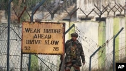 An Indian soldier takes position outside an army camp at Nagrota, in the outskirts of Jammu, Nov. 29, 2016.