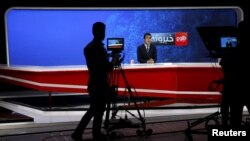 FILE - FILE - A news anchor is seen on camera during a broadcast at Tolo News studio, in Kabul, Afghanistan, Oct. 18, 2015.