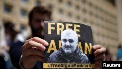FILE - A man attends a rally to support an Azerbaijani journalist Afgan Mukhtarli, who was abducted in Tbilisi on May 29, then held in detention in Baku, in Tbilisi, Georgia, May 31, 2017.